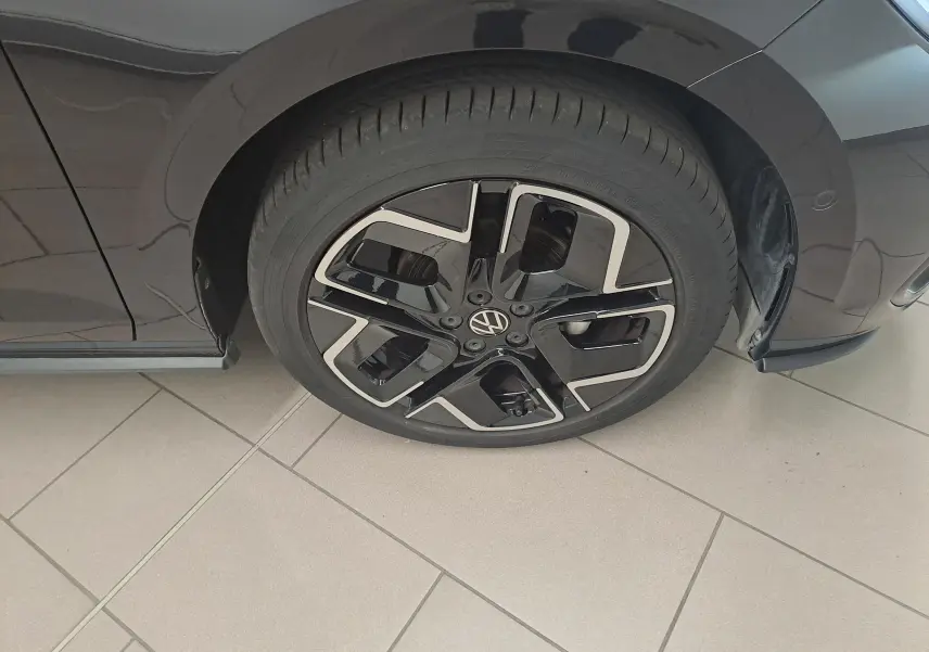Gros plan sur la roue avant droite d'une Volkswagen Polo 1.0 TSI R-Line noire avec jante alliage noir et argent.