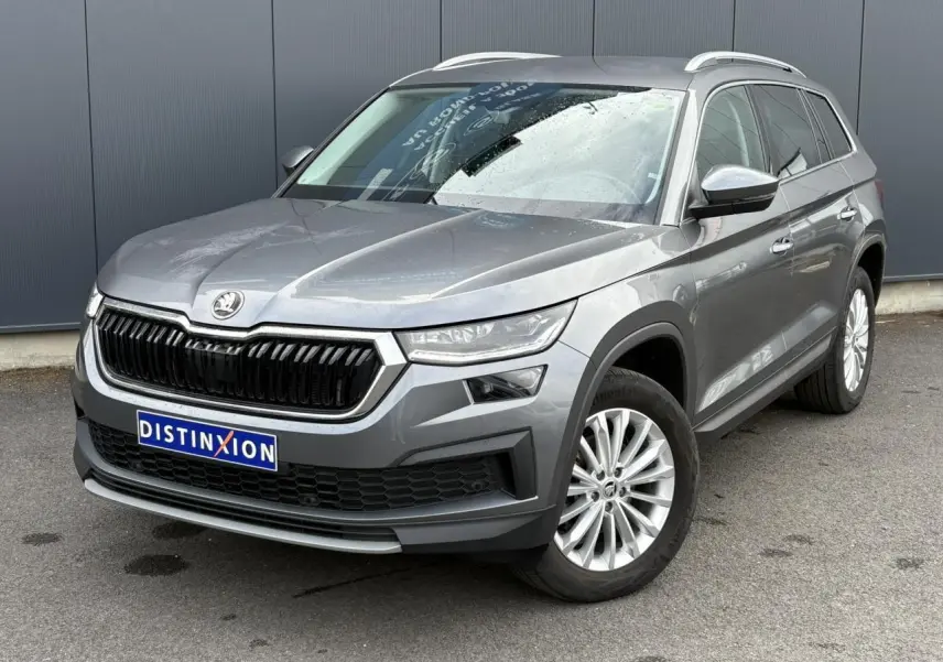 SKODA KODIAQ gris graphite vu en 3/4 avant droit, avec calandre noire et jantes alliage 18 pouces.