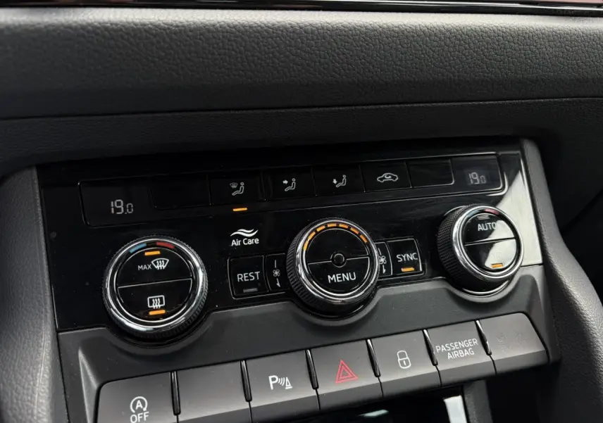 Gros plan sur la console de climatisation automatique bi-zone du Skoda Kodiaq gris graphite, avec commandes rotatives et affichage digital.