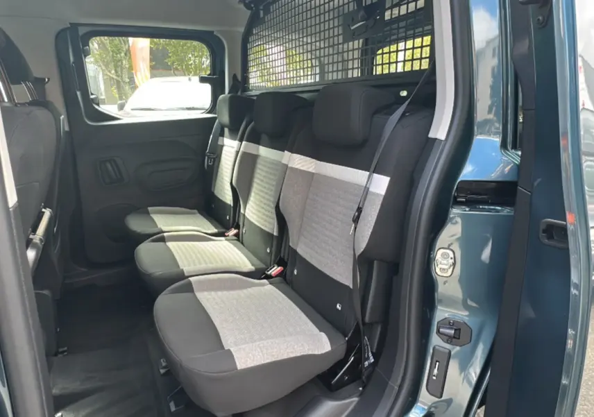 Vue intérieure côté droit du Citroën Berlingo 2025 Kiama blue, montrant les sièges arrière et la grille de séparation.