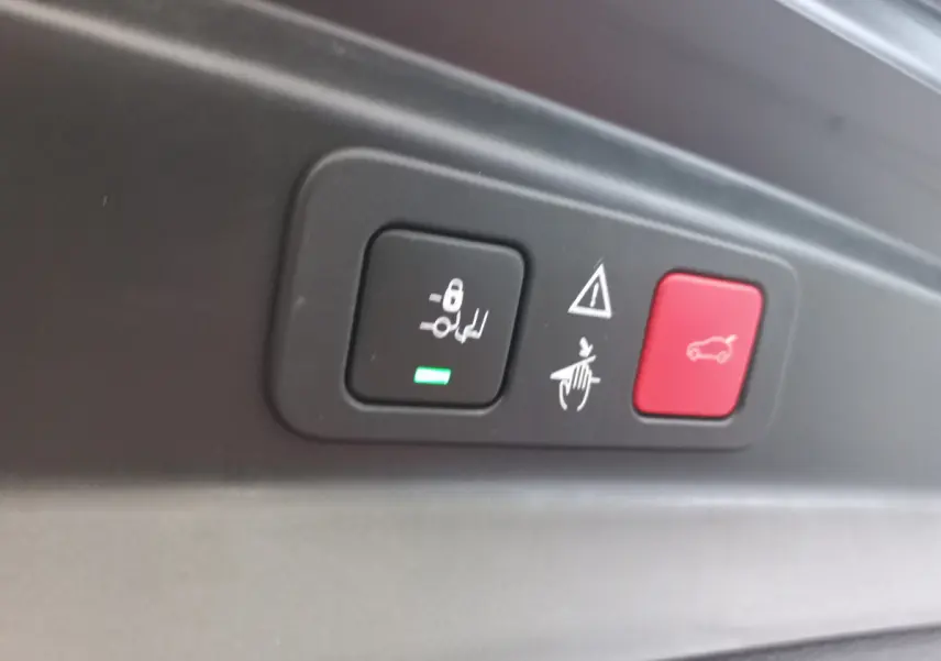 Gros plan sur les boutons de commande de la fermeture et alarme du coffre du Peugeot 5008 gris foncé.
