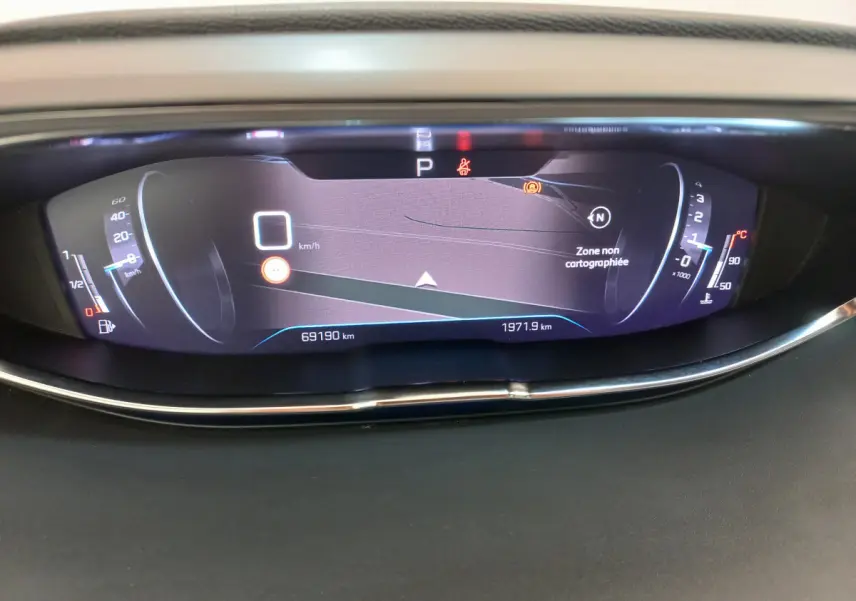 Affichage numérique du tableau de bord du Peugeot 5008 gris foncé, indiquant vitesse et informations de navigation.