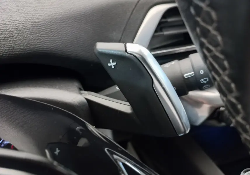 Gros plan sur la palette de changement de vitesse + côté droit du volant cuir du Peugeot 5008 gris foncé 2021.