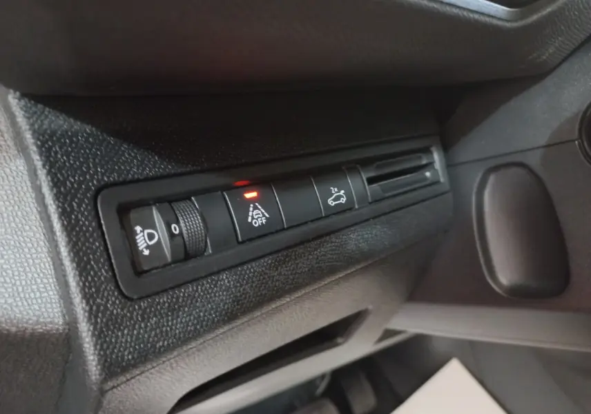 Détail des commandes d'éclairage et d'assistance sur le côté gauche du tableau de bord noir du Peugeot 5008 gris foncé.