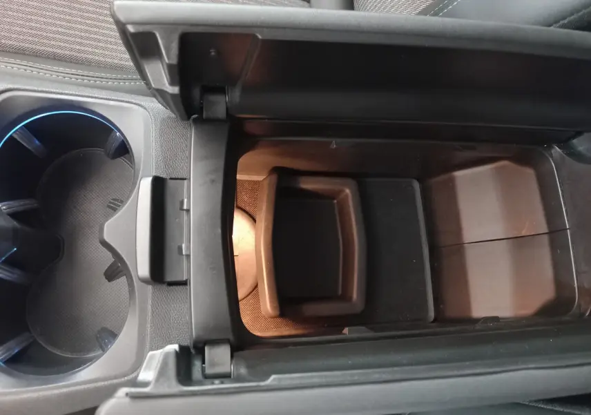 Vue rapprochée de la console centrale ouverte avec rangement et porte-gobelets du Peugeot 5008 gris foncé 2021 Allure Pack.