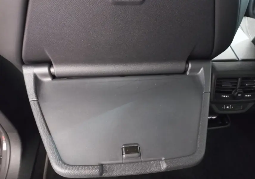 Détail de la tablette rabattable noire au dos du siège avant dans l'habitacle du Peugeot 5008 gris foncé