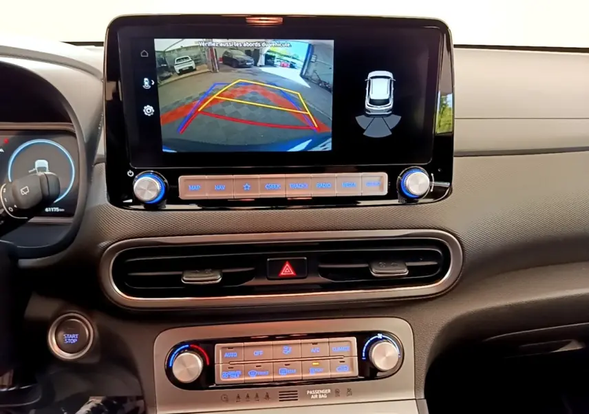 Vue intérieure du tableau de bord de la Hyundai Kona électrique 2023 avec écran tactile affichant la caméra de recul.