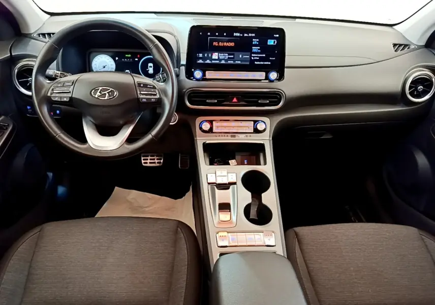 Vue intérieure du tableau de bord et volant cuir multifonctions du Hyundai Kona électrique 2023, avec écran tactile central.