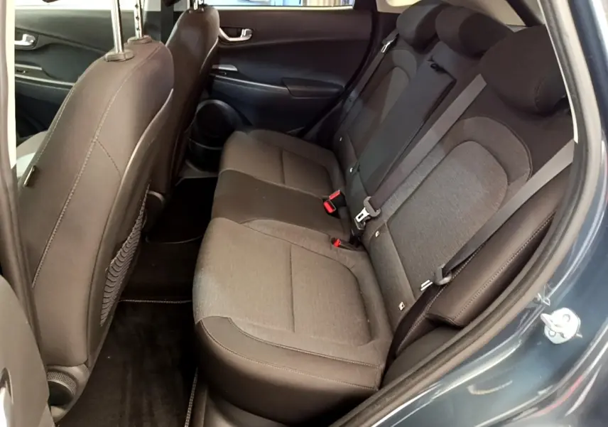 Vue côté gauche arrière montrant la banquette trois places en tissu gris du Hyundai Kona bleu électrique 2023.