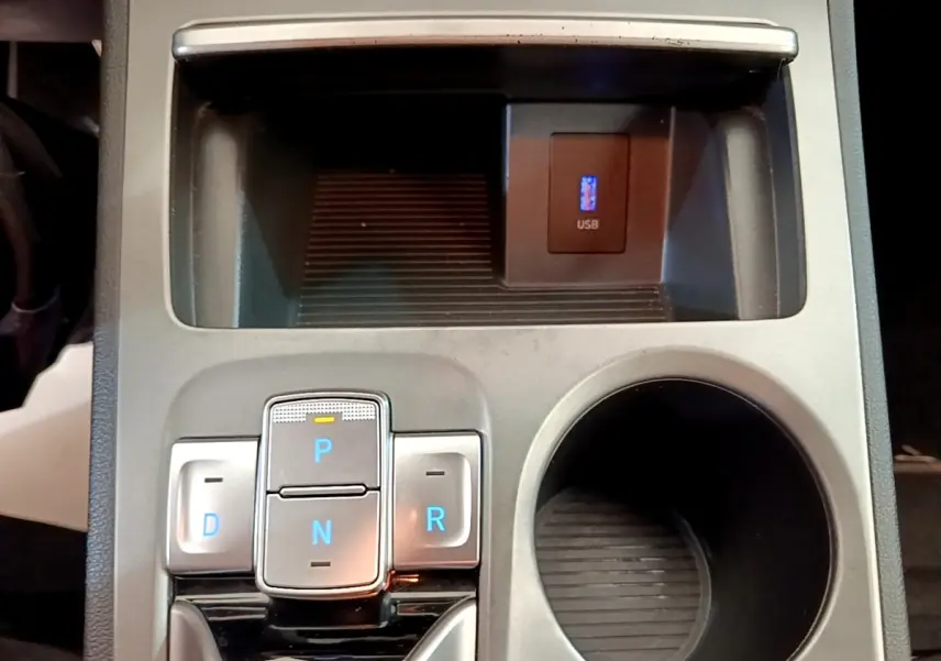 Vue rapprochée de la console centrale du Hyundai Kona électrique 2023, avec boutons de boîte auto et prise USB.