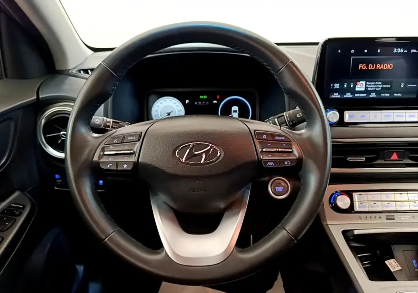 Vue intérieure centrée sur le volant cuir multifonctions noir du Hyundai Kona électrique 2023 avec tableau de bord numérique.