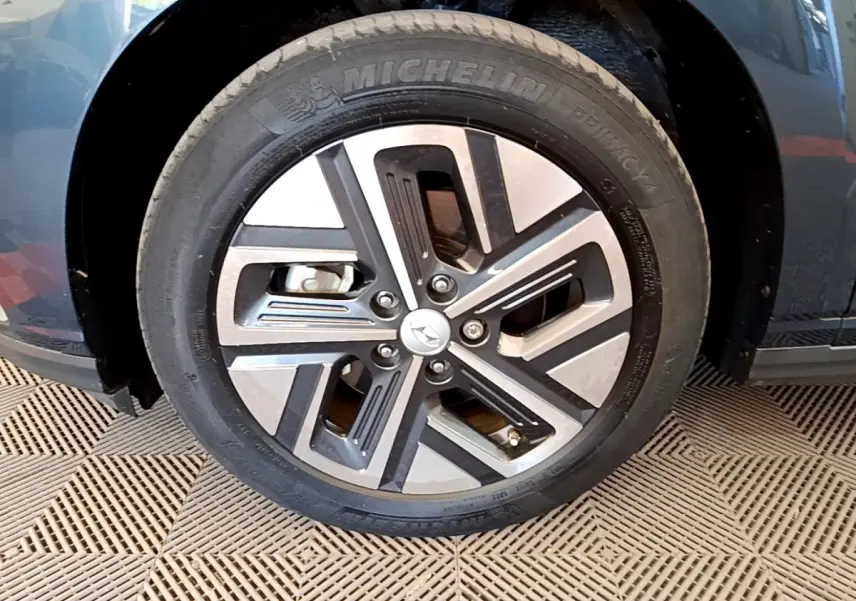 Gros plan sur la roue avant gauche du Hyundai Kona électrique bleu, avec jante alliage et pneu Michelin.