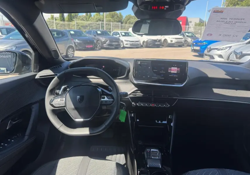 Vue intérieure du tableau de bord et volant du Peugeot 2008 Hybrid 136 e-DCS6 Allure noir avec écran tactile et pack hiver.