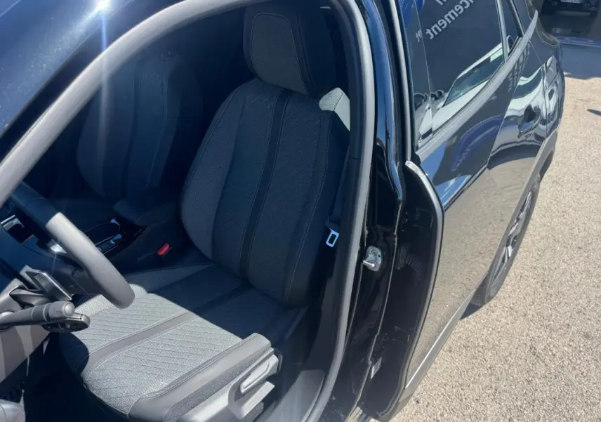 Vue côté gauche intérieur du siège avant d’une Peugeot 2008 Hybrid 136 Allure noir avec porte ouverte au soleil.