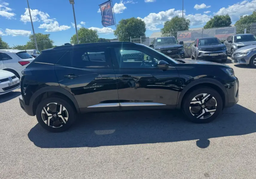 Vue de profil côté gauche d’un Peugeot 2008 Hybrid 136 e-DCS6 Allure noir 2025 avec jantes distinctives et pack hiver.