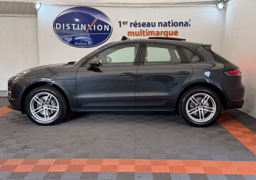 Vue latérale droite d'un Porsche Macan 3.0 S gris foncé avec jantes alliage cinq branches en intérieur showroom.