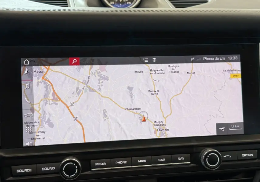 Écran tactile de navigation affichant une carte GPS dans le tableau de bord d'un Porsche Macan 3.0 S gris foncé.
