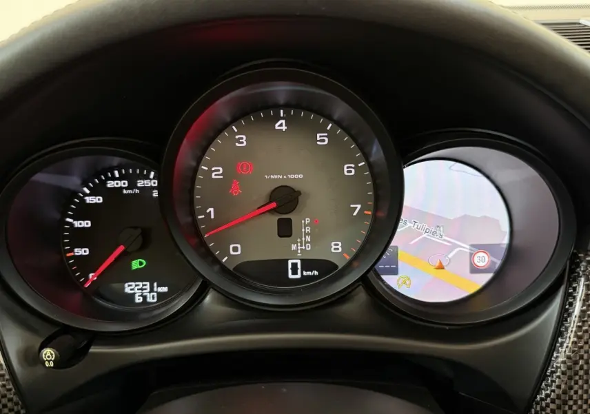 Vue rapprochée du tableau de bord du Porsche Macan 3.0 S 2019, affichage numérique et compteur tachymètre central.