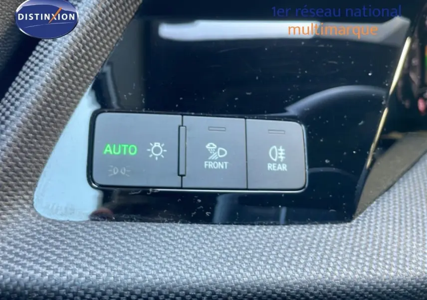 Gros plan sur les commandes d'éclairage avec bouton AUTO vert sur tableau de bord noir de l'Audi A3 Sportback.