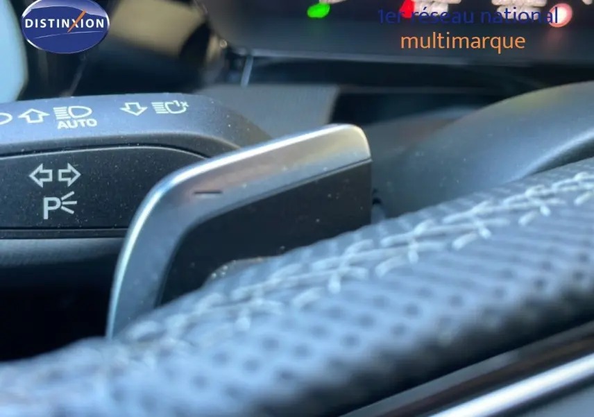 Détail du volant noir avec palettes de changement de vitesse et commandes d’éclairage sur Audi A3 Sportback 40 TFSIe 2025.
