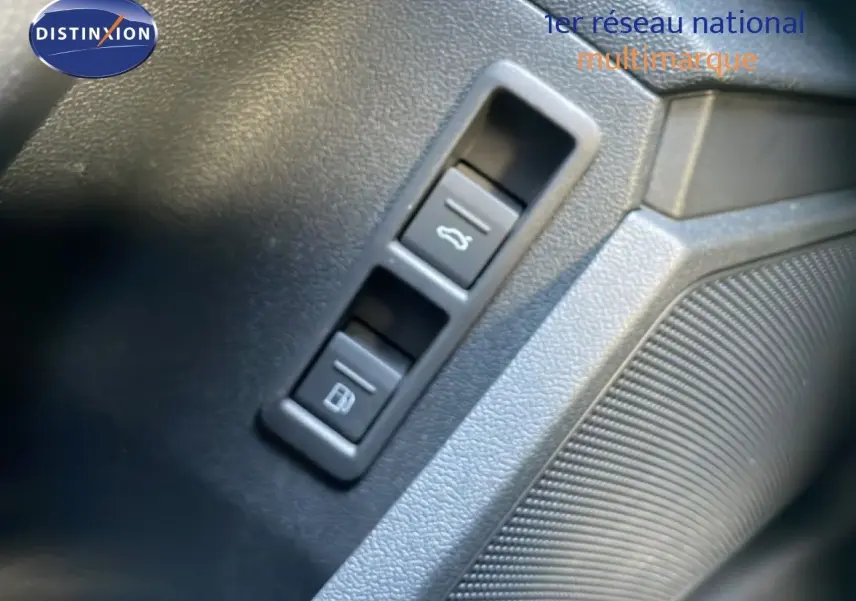 Détail des boutons d'ouverture du coffre et de la trappe à carburant sur la porte côté conducteur d'une Audi A3 Sportback noire.