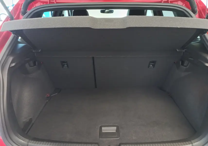 Coffre ouvert vu de l'arrière d'une Volkswagen Polo Rouge Roi 2025, version R-Line Edition avec cache-bagages déployé.