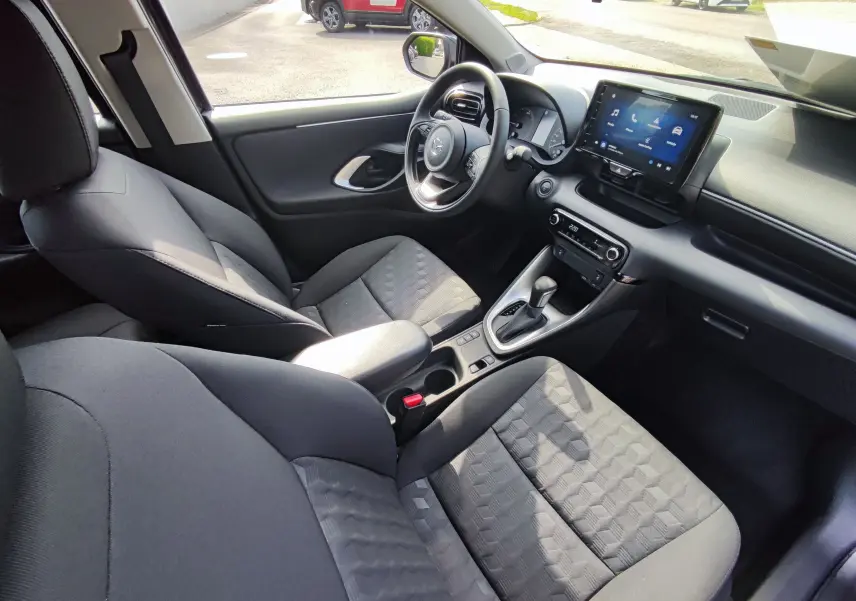 Intérieur noir de la Mazda2 2024, vue côté conducteur, avec écran tactile et console centrale moderne.