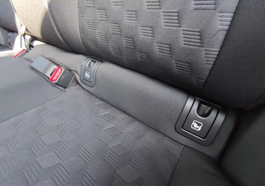 Détail des fixations ISOFIX sur la banquette arrière en tissu noir du Mazda2 hybride 2024.