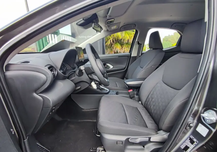 Intérieur avant de la Mazda2 2024 gris foncé, vue côté gauche montrant sièges noirs et tableau de bord moderne.