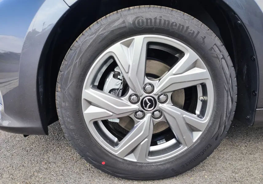 Gros plan sur la roue avant droite gris foncé d'une Mazda2 1.5 Hybrid Exclusive Line 2024 avec jante alliage et pneu Continental.