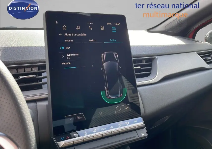 Vue intérieure du tableau de bord du Renault Captur E-Tech hybride 2025, avec écran tactile central affichant l'aide au stationnement.