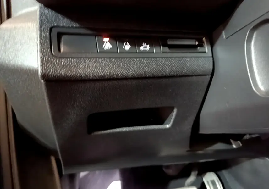 Gros plan sur les commandes sous le tableau de bord côté conducteur du Peugeot 5008 GT bleu 2021.