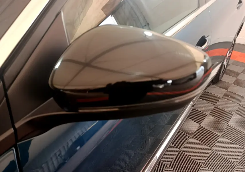 Rétroviseur droit noir brillant du Peugeot 5008 bleu, vue rapprochée côté droit avec reflet intérieur.