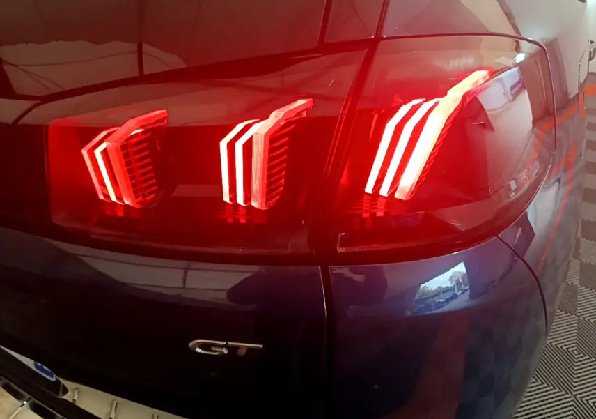 Gros plan sur le feu arrière droit rouge et badge GT du Peugeot 5008 bleu, version PureTech 130 S&S EAT8 GT.