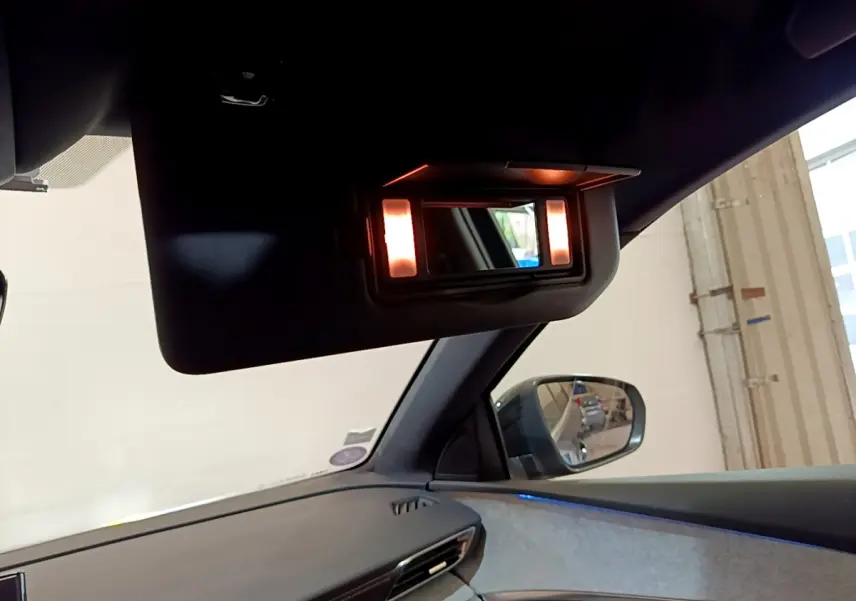 Miroir de courtoisie éclairé sur pare-soleil côté passager intérieur d’un Peugeot 5008 bleu, vue latérale droite.