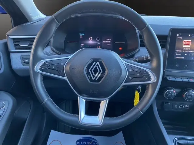 Vue rapprochée du volant noir de la Renault Clio V PH2 TCE 90 Evolution avec tableau de bord numérique et écran multimédia.