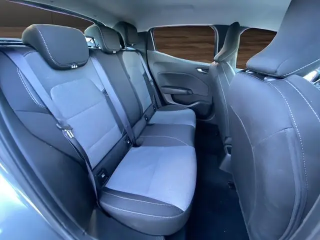 Vue intérieure de la banquette arrière grise et noire de la Renault Clio V PH2 TCE 90 Evolution avec ceintures et appuie-têtes.