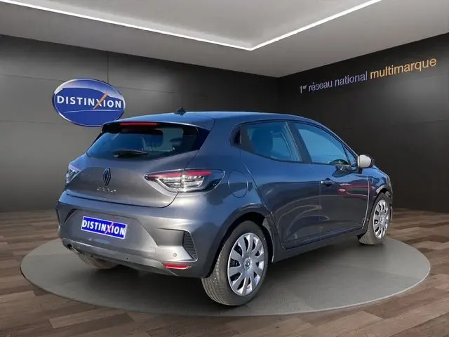 Vue 3/4 arrière droite d'une Renault Clio V gris schiste avec feux LED et enjoliveurs 16 pouces en showroom.