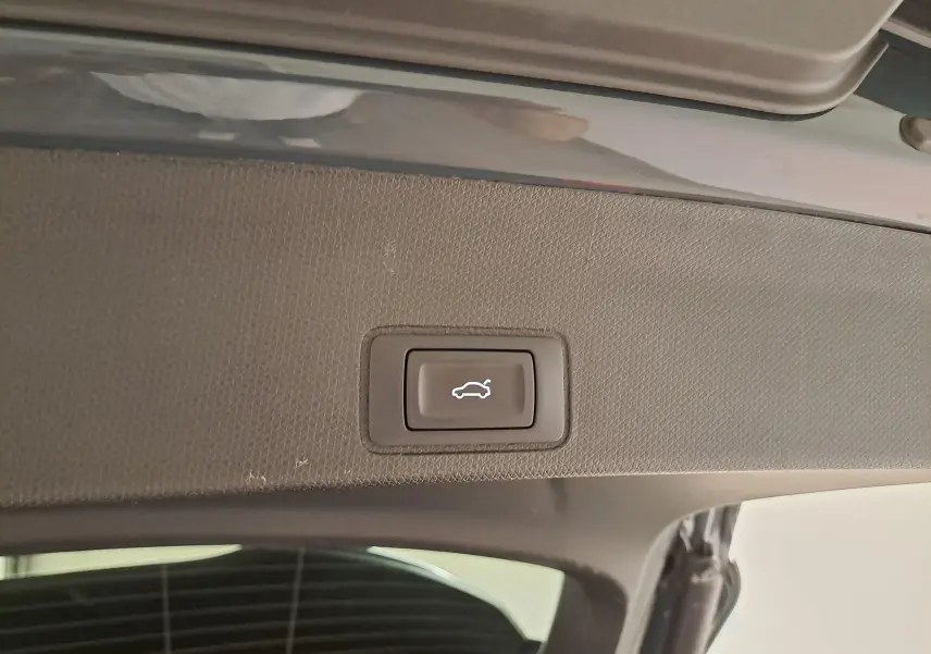 Bouton d'ouverture électrique du coffre sur la partie intérieure du hayon d'un CUPRA TERRAMAR bleu Fjord.