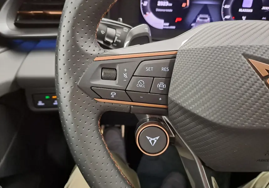 Gros plan sur le volant perforé avec commandes intégrées et logo CUPRA, intérieur moderne du TERRAMAR 2025.