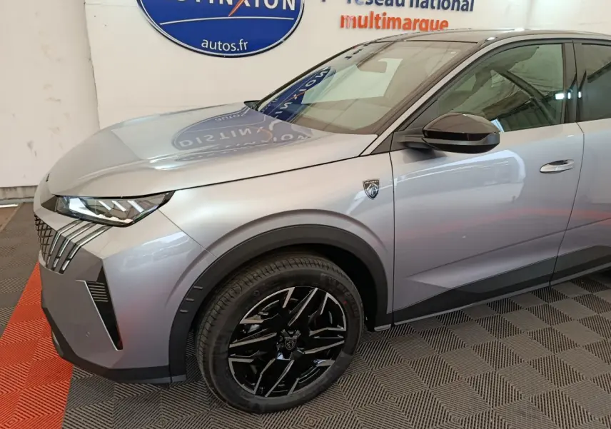 Vue 3/4 avant gauche d'un Peugeot 3008 gris clair avec jantes noires et badge distinctif sur l'aile avant.