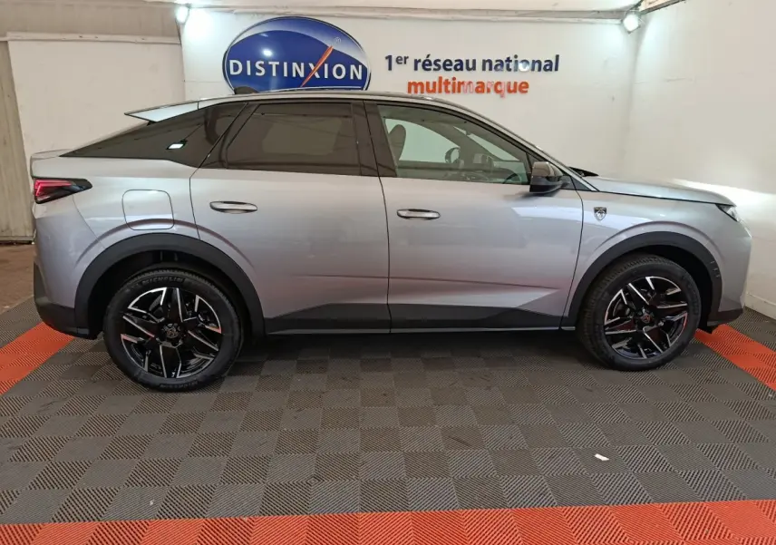 Profil côté gauche d'un Peugeot 3008 gris clair 2025 avec jantes noires et toit noir dans un showroom
