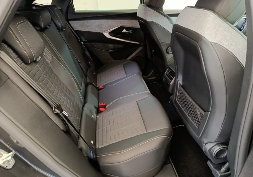 Vue intérieure côté droit des sièges arrière gris foncé du Peugeot 3008 1.2 HYBRID 145 E-DCS6 GT 2025 avec surpiqûres claires.