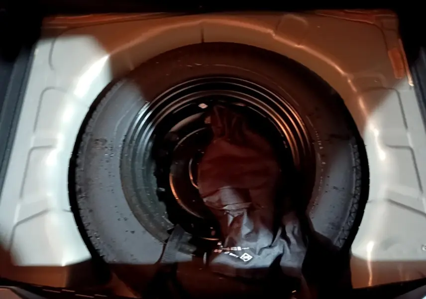 Gros plan sur la roue de secours noire logée dans le coffre du Renault Captur jaune, version Intens 2020.