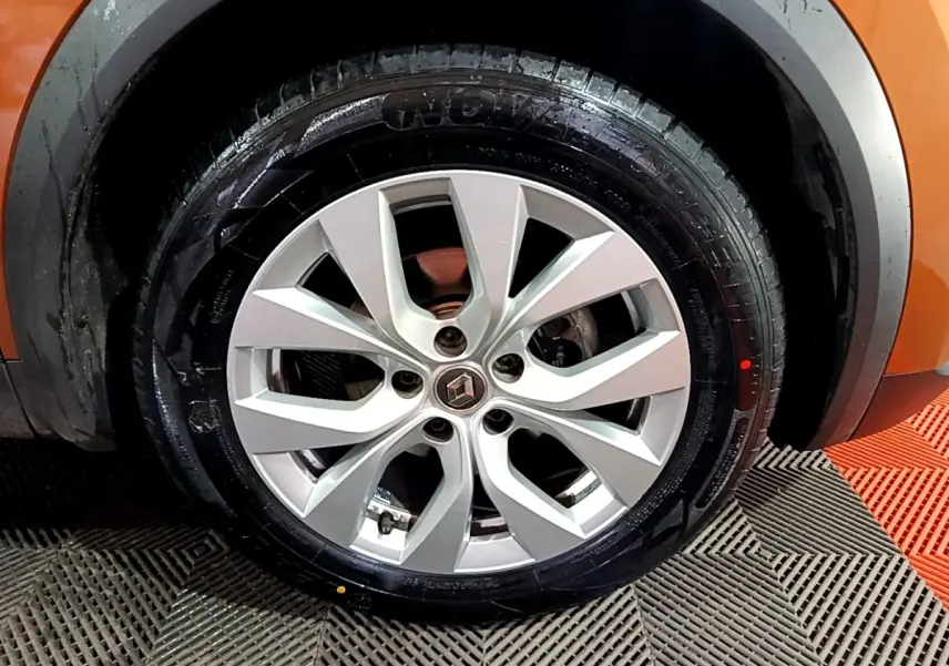 Gros plan sur la roue avant droite avec jante argentée du Renault Captur jaune 2020 Intens Blue dCi 115 EDC.