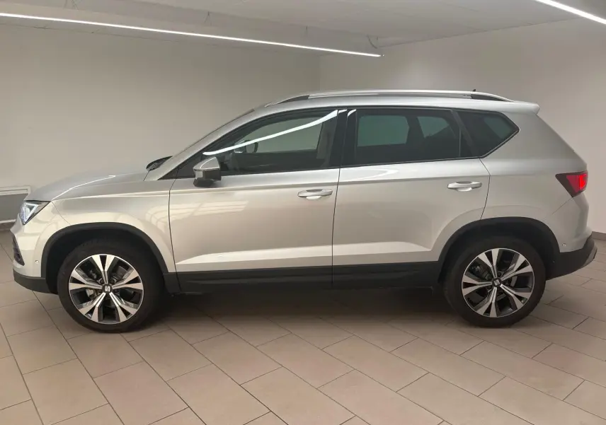 Vue de profil côté gauche du SEAT Ateca 2025 en Argent Reflex, avec jantes alliage 18 pouces et hayon électrique.