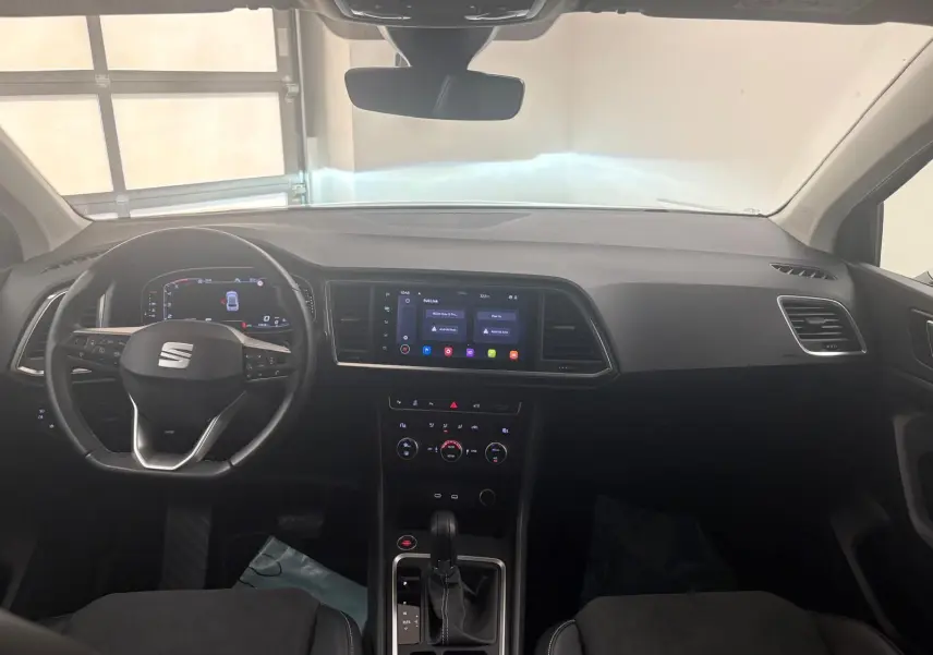 Vue intérieure avant du tableau de bord du SEAT Ateca 2.0 TDI 150 DSG7, avec écran tactile central et volant multifonction.