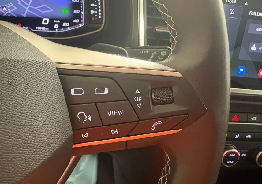 Gros plan sur les commandes au volant du SEAT Ateca 2025, avec affichage numérique et finition noire.