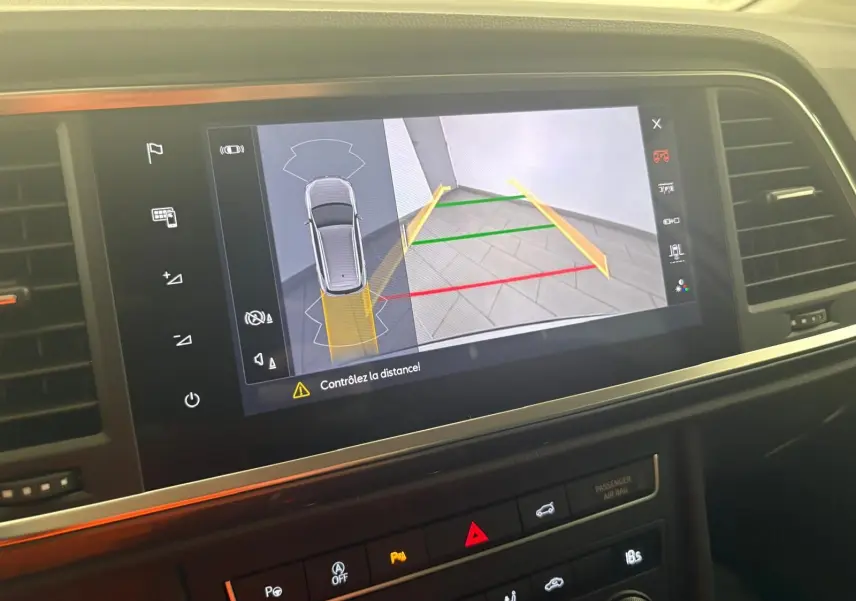 Écran tactile intérieur montrant la caméra de recul avec guidage coloré du SEAT Ateca Argent Reflex, vue de face.
