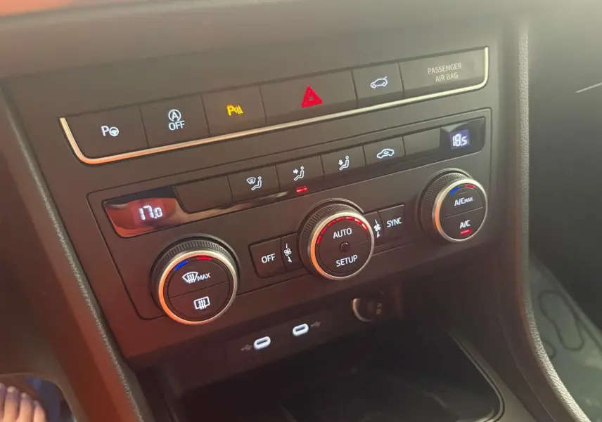 Vue rapprochée de la console centrale du SEAT Ateca 2025, montrant les commandes de climatisation et les ports USB.
